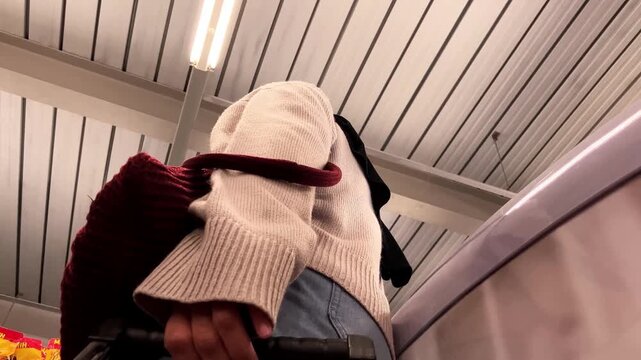 low angle video of a housewife shopping in a supermarket. The camera is placed inside the shopping cart, looking up at her as she pushes it through the aisles.