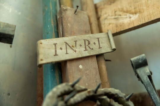 Close-up of a wooden INRI plaque on a crucifix under restoration, Gers, Saint Georges, France