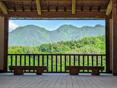 Scenic view of green mountains framed by a wooden pavilion balcony in Ueda Nagano Japan