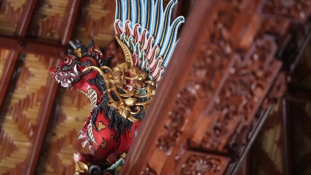 Ornate Painted Wooden Singha Statue Adorning Balinese Traditional Pavilion