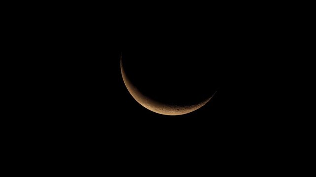 Minimalist shot of a delicate crescent moon glowing in the expansive sky