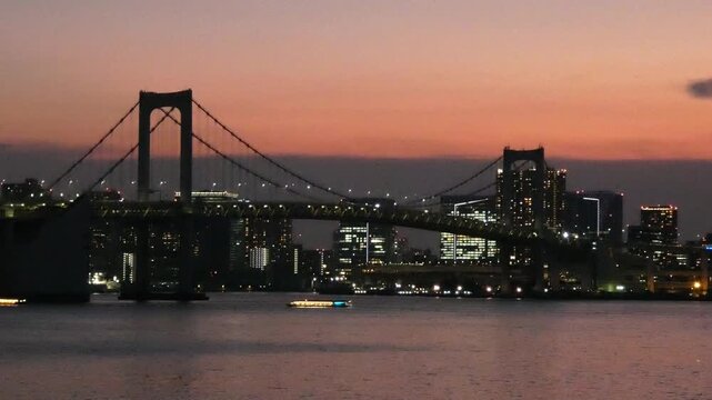 A static long-shot video of the Rainbow Bridge in Minato Ward, Tokyo, at sunset.