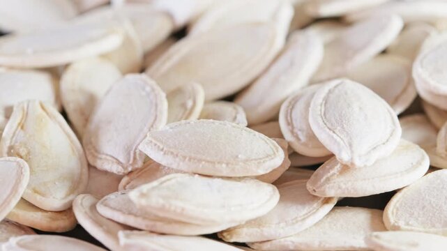 Rotating pile of hulled pumpkin seeds close-up