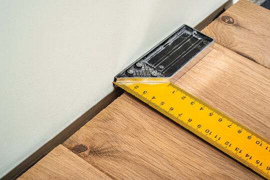 Mandatory expansion gap measurement between wall and natural solid oak floor plank