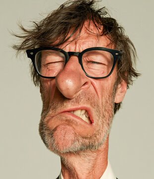 Funny man with messy hair and glasses grimacing