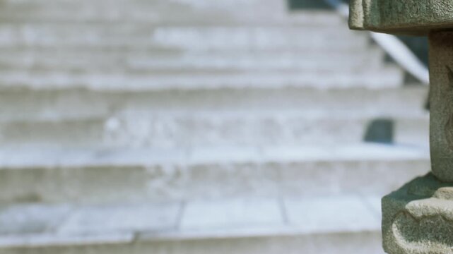 Visitors walk up the steps in a busy location. The stone railing adds detail to the architecture while people pass by in the bright day light.