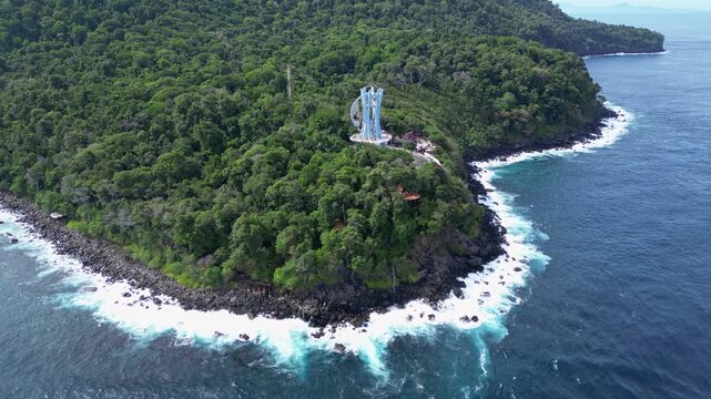 Weh Island, Indonesia : Aerial drone footage of 0 kilometer monument in Weh island of Aceh, Indonesia surrounded by rain forest. Taken with orbit motion showing wave from Andaman sea 