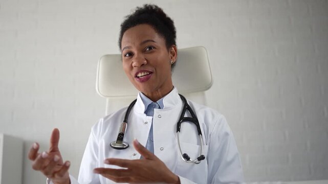 Friendly female physician speaking and listening to patient during virtual medical appointment. Warm professional communication in remote healthcare consultation