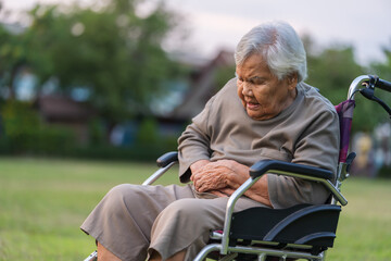 senior woman suffering from stomach ache while sitting in wheelchair at park © geargodz