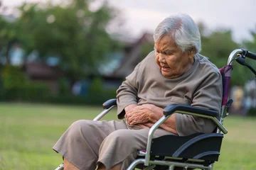 senior woman suffering from stomach ache while sitting in wheelchair at park © geargodz