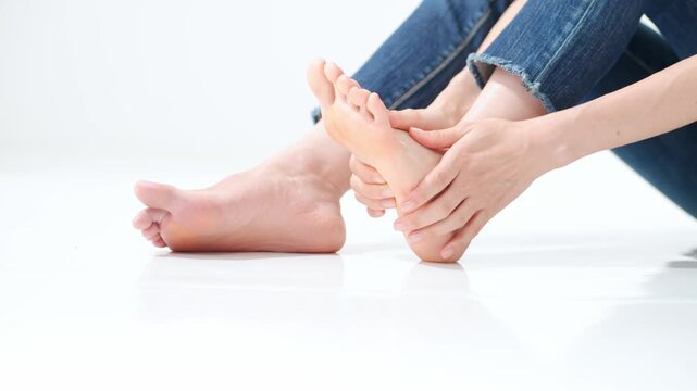 A woman massaging the soles of feet. Massage, foot care, acupressure, corns, calluses, warts, athlete's foot, arches, plantar fasciitis, flat feet.