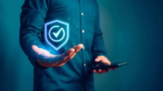 Man holding a digital shield icon for cybersecurity, data protection, and network security. This secure technology concept ensures safety, trust, and insurance for business.