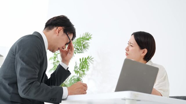 面談する男女。接客、相談、悩み、疑問、困る、不安、心配、ビジネス、PC、説明、顧客、謝罪、女性、男