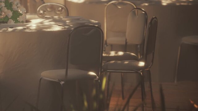 A serene space filled with elegantly set tables and chairs under warm natural light. Soft shadows dance on the surfaces, creating a calming ambiance perfect for gatherings.