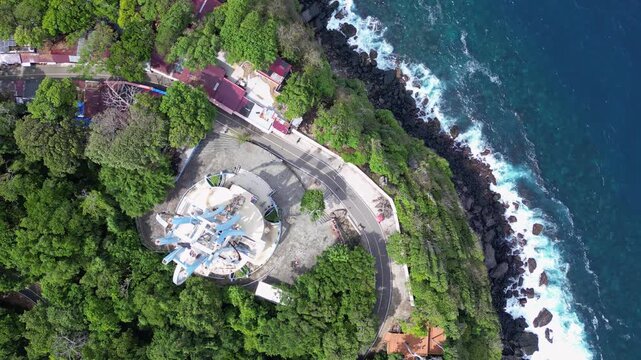 Weh Island, Indonesia : Top down aerial drone footage above 0 kilometer monument in Weh island of Aceh, Indonesia surrounded by rain forest. Taken with rotation motion showing wave from Andaman sea br