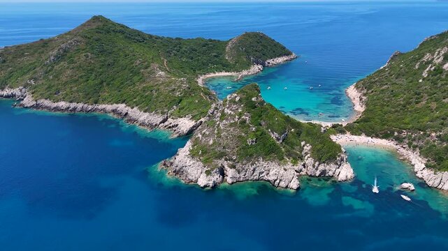 Aerial view of Porto Timoni beach with turquoise water and lush green hills on the coastline of Kerkira, Greece.