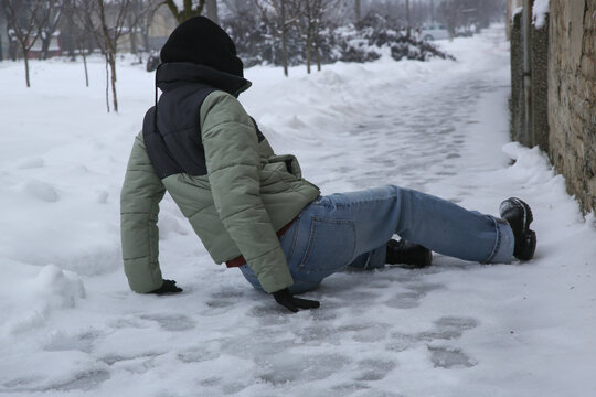 Winter Slip and Risk of Fall Accidents in Winter - a woman slips on an ice-covered road is a common winter hazard, leading to potential injuries