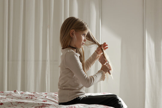 Little Girl with Long Blonde Hair Brushing Hair Before Bed