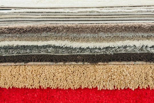 Stacked carpet samples showing different textures and colors