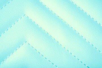 Obraz premium Soft light blue quilted fabric texture with a distinctive diagonal zigzag stitching pattern background