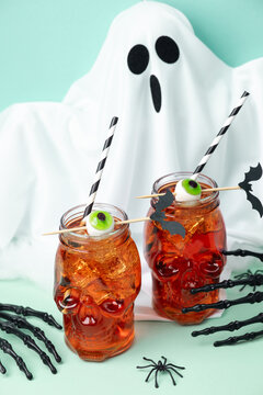 Spooky Halloween drinks with ghost and spider decorations on mint background