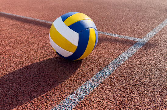 volleyball. blue with yellow color ball on the playground. volleyball cover, red. ball game