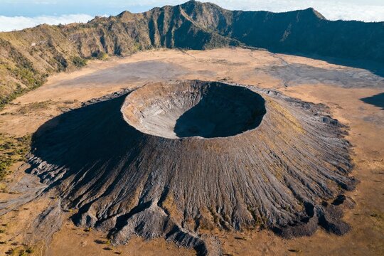 Aerial view of a volcanic crater in a rugged mountainous landscape