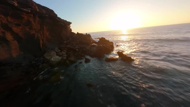 Aerial View of a Rocky Sandy Beach at Golden Hour Sunset