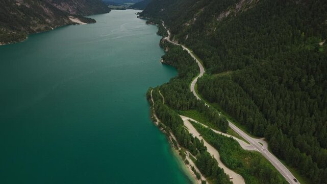 Scenic view of Lake Achensee in Tyrol, Austria, showing the alpine lake, forested shoreline and surrounding mountain landscape - drone shot
