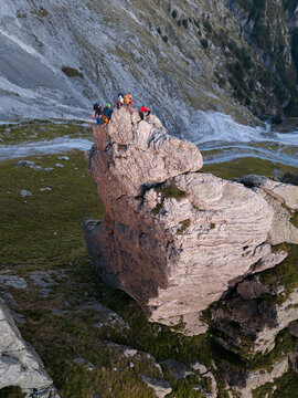 Aerial view of climbers scaling the rocky pinnacle of Punta Carina with ropes and gear in the rugged mountains of Minucciano, Toscana, Italy.
