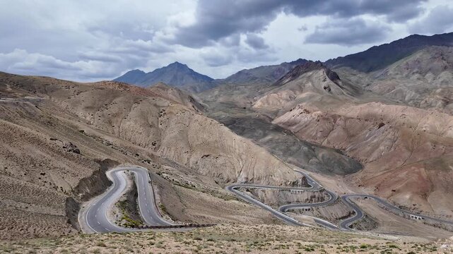 Zanskar, India : Time wrap panoramic footage of Fotu La, famous mountain pass in Srinagar - Leh highway in Ladakh, India showing winding mountain road surrounded by arid mountain under dramatic sky 
