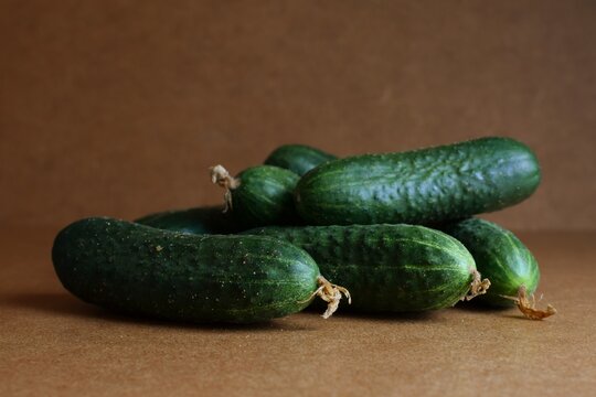 Green cucumbers on a brown background