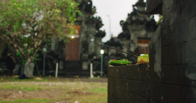 Incense offering placed at Balinese Hindu temple during ritual in Bali Indonesia