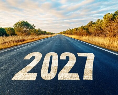 Asphalt road straight view with year 2027 concept on floor going towards the bright horizon morning.