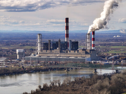 Aerial view of the Nikola Tesla Power Plant A with its prominent chimneys emitting smoke along the Sava River in Urovci, Grad Beograd, Serbia.