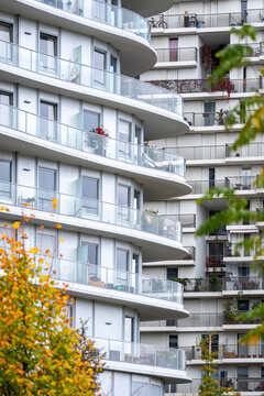 Modern apartments in Clichy-Batignolles Paris France feature balconies beside autumn foliage within a dense urban development setting