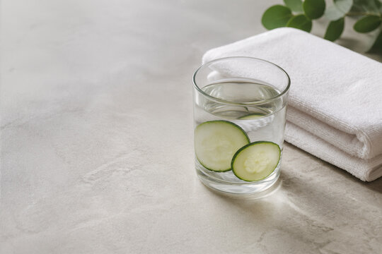 Verre d'eau au concombre et serviettes blanches