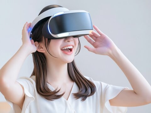VRヘッドセットを装着しバーチャルリアリティの世界に驚き笑顔を見せる女性