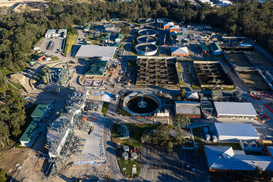 Aerial view of the Rouse Hill water resource recovery facility featuring circular clarifiers, aeration tanks, and industrial buildings under construction in Rouse Hill, New South Wales, Australia.