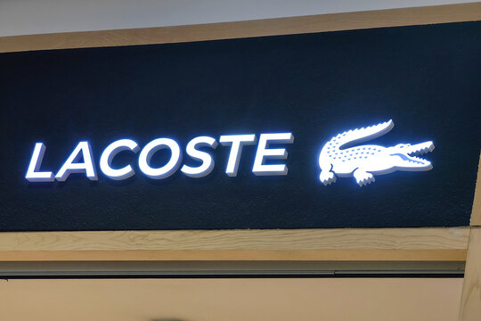 Almaty, Kazakhstan - August 17, 2026: Lacoste storefront sign glowing with the crocodile logo at the mall