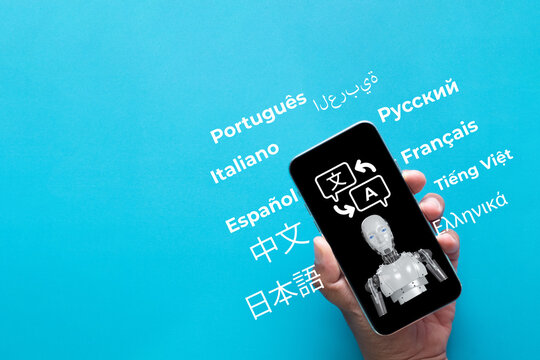 Hand holding a smartphone with an AI robot and translation icon on screen, surrounded by international language words. Concept of AI translator, machine learning, and global communication.