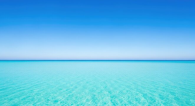 A serene landscape featuring crystal clear turquoise ocean water meeting a bright blue cloudless sky at a perfectly straight horizon line, sky, wave, scenic