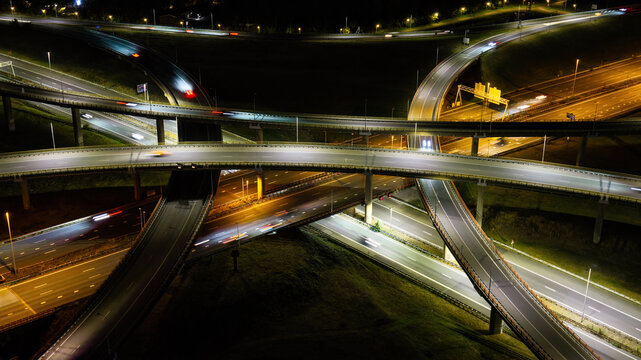 Aerial view of the Westvliet highway intersection at night with illuminated roads and light trails from moving vehicles in Den Haag, Zuid-Holland, Netherlands.
