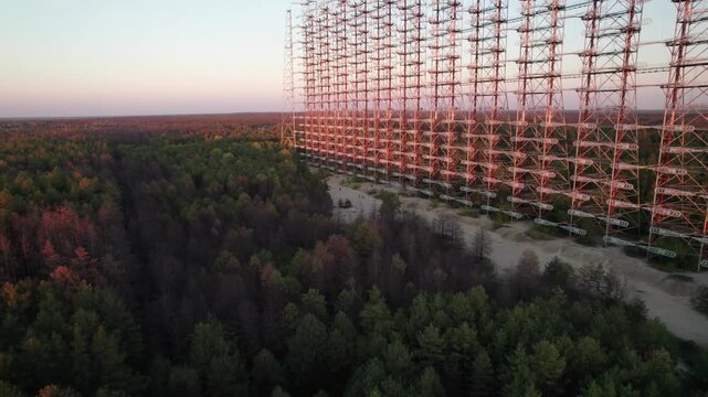 Aerial view of the massive Duga 1 Receiver radar structure rising above the dense forest landscape in Chernobyl, Kyiv Oblast, Ukraine.