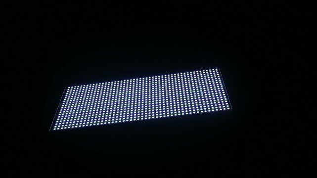 A bright LED light panel glowing in the dark.