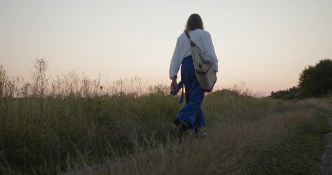 Caucasian man with long hair and Ukrainian traditional folk attire walk wandering near river. 4K 10-bit
