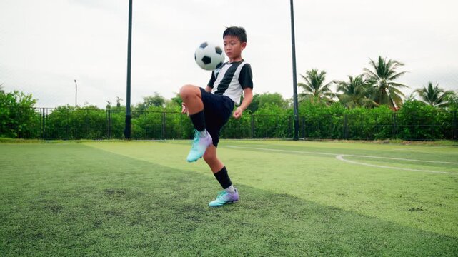 Kid boy leg kicking soccer ball on green grass field action. conceptual metaphor for youth sports training team competition fitness health wellness and active lifestyle	
