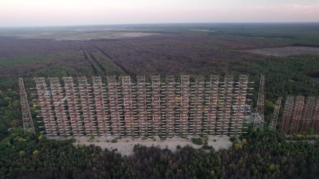 Aerial view of the massive Duga 1 Receiver radar array rising above the dense forest in the exclusion zone near Chernobyl, Kyiv Oblast, Ukraine.