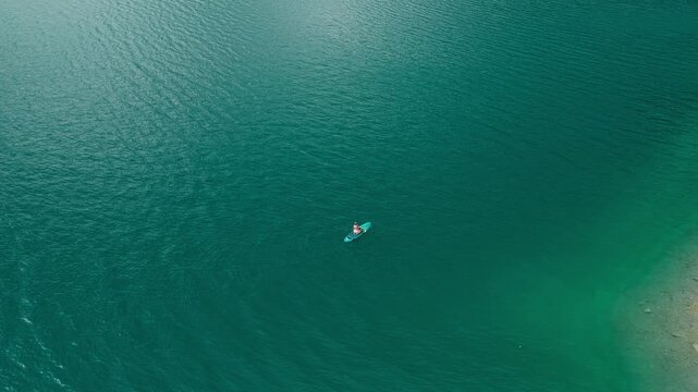 Tourist Paddleboarding Across Tranquil Waters Of Lake Achensee In Tyrol, Austria. Aerial Drone Shot