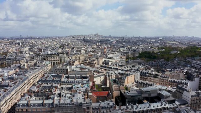 Aerial view of the sprawling Paris cityscape featuring dense historic architecture, classic rooftops, and urban streets in Paris, Ile-de-France, France.